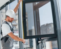 Focused on the work. Repairman is indoors in the modern room window replacement perkasie pa