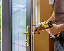 Install the door handle with a lock, Carpenter tighten the screw, using an electric drill screwdriver, close-up.