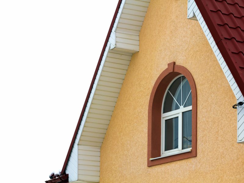 Low angle view of the upper floors of a new large house. Window and roof detail of residential home building. Real estate property. custom window installation
