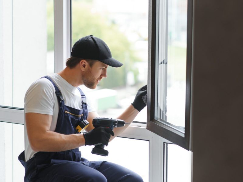 service man installing window with measure tape service man installing window with measure tape.