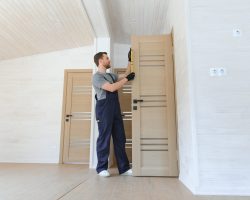 Young man fixing the door in house.